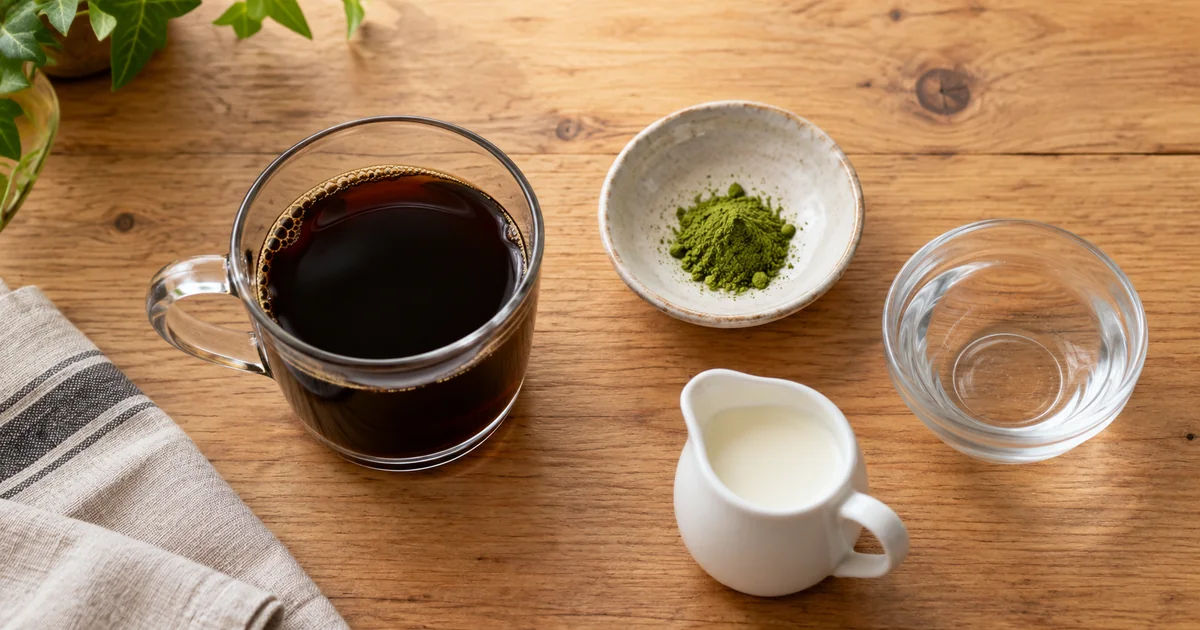 コーヒー、少量の青汁粉末、水、ミルクを並べた1杯分の材料
